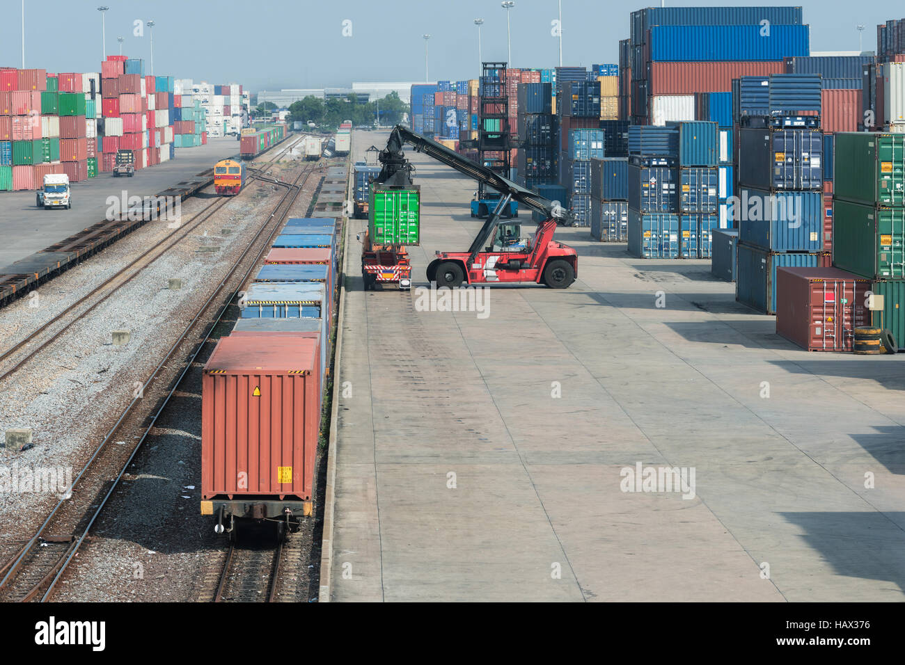 Treno merci piattaforma con treno merci contenitore al magazzino porta in uso per logistica di esportazione sullo sfondo Foto Stock