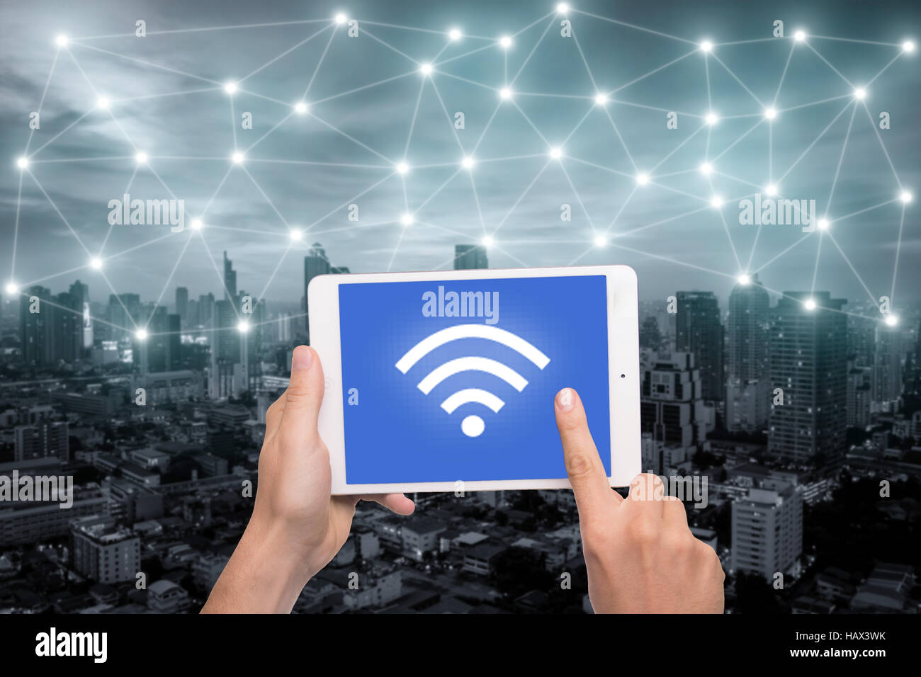 Mano che tiene compressa con l'icona wifi sulla città e la connessione di rete del concetto. Bangkok smart city e la rete di comunicazione wireless, immagine astratta vi Foto Stock