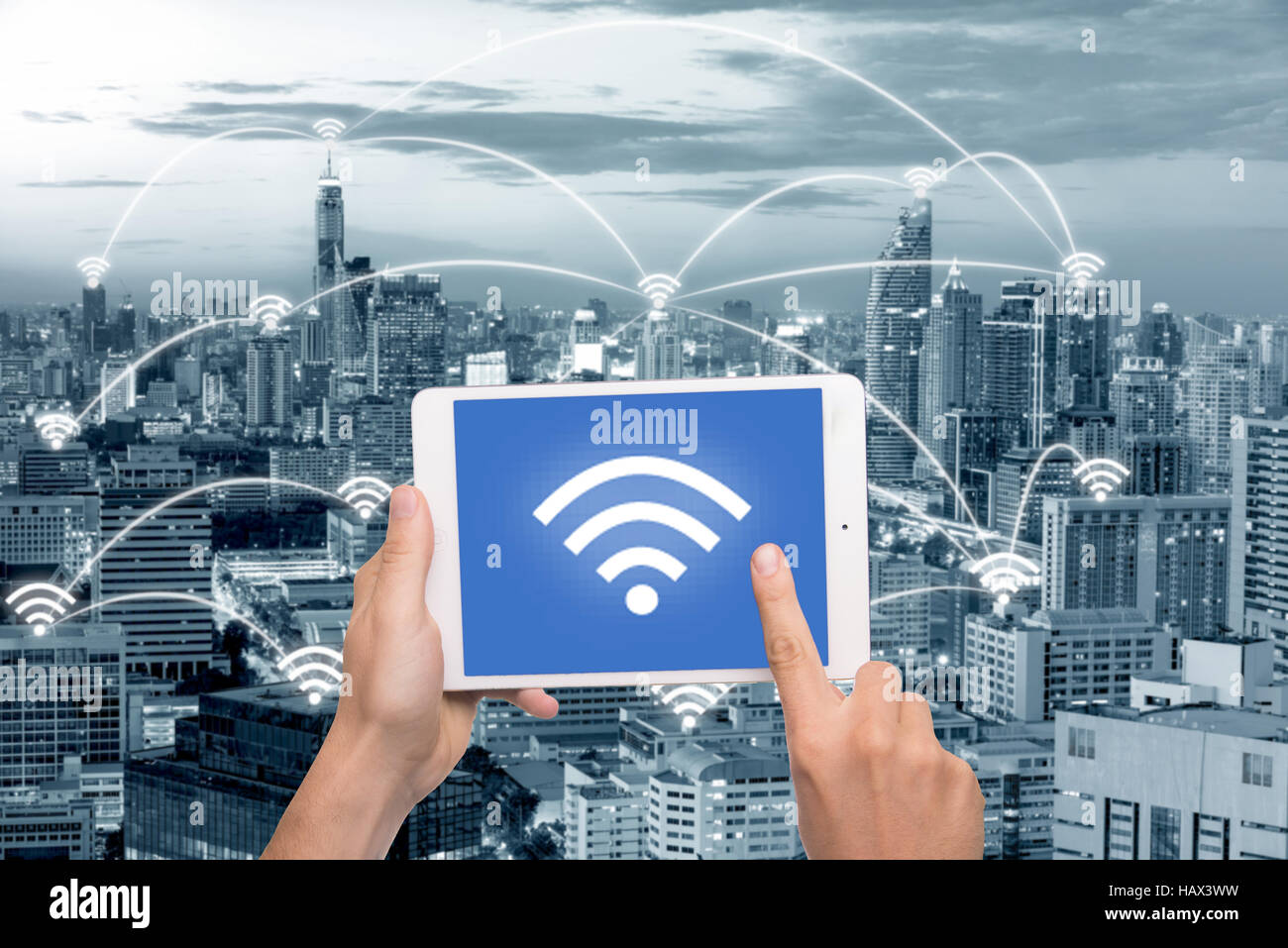 Mano che tiene compressa con l'icona wifi sulla città e la connessione di rete del concetto. Bangkok smart city e la rete di comunicazione wireless, immagine astratta vi Foto Stock