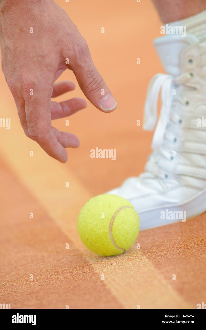 Primo piano della mano raggiungendo per la palla da tennis Foto Stock