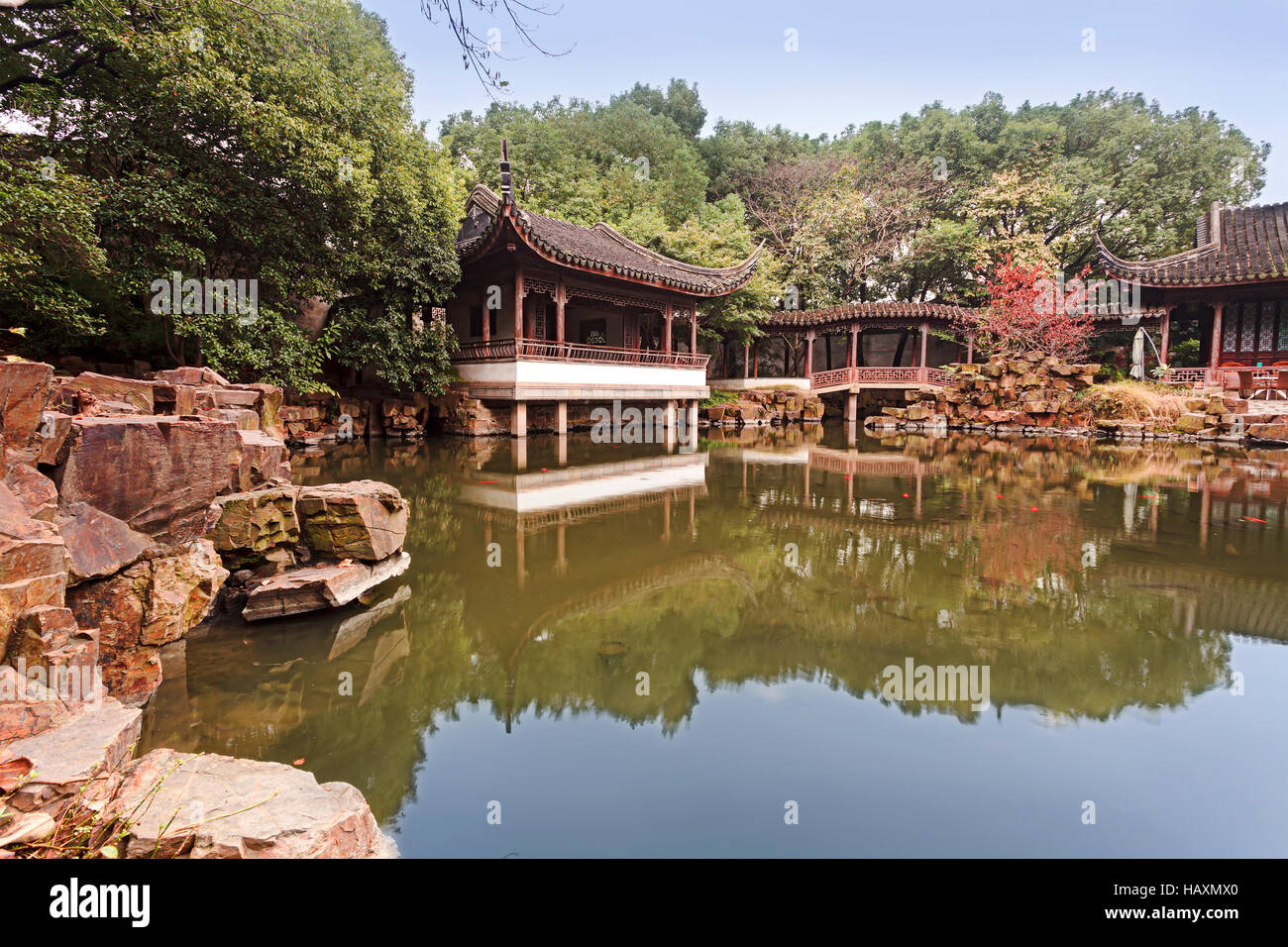 Cinese tradizionale pavilion , Ponte e casa riflettendo ancora in acqua di stagno tranquilla all'interno di pareti del giardino cinese di Suzhou. Foto Stock