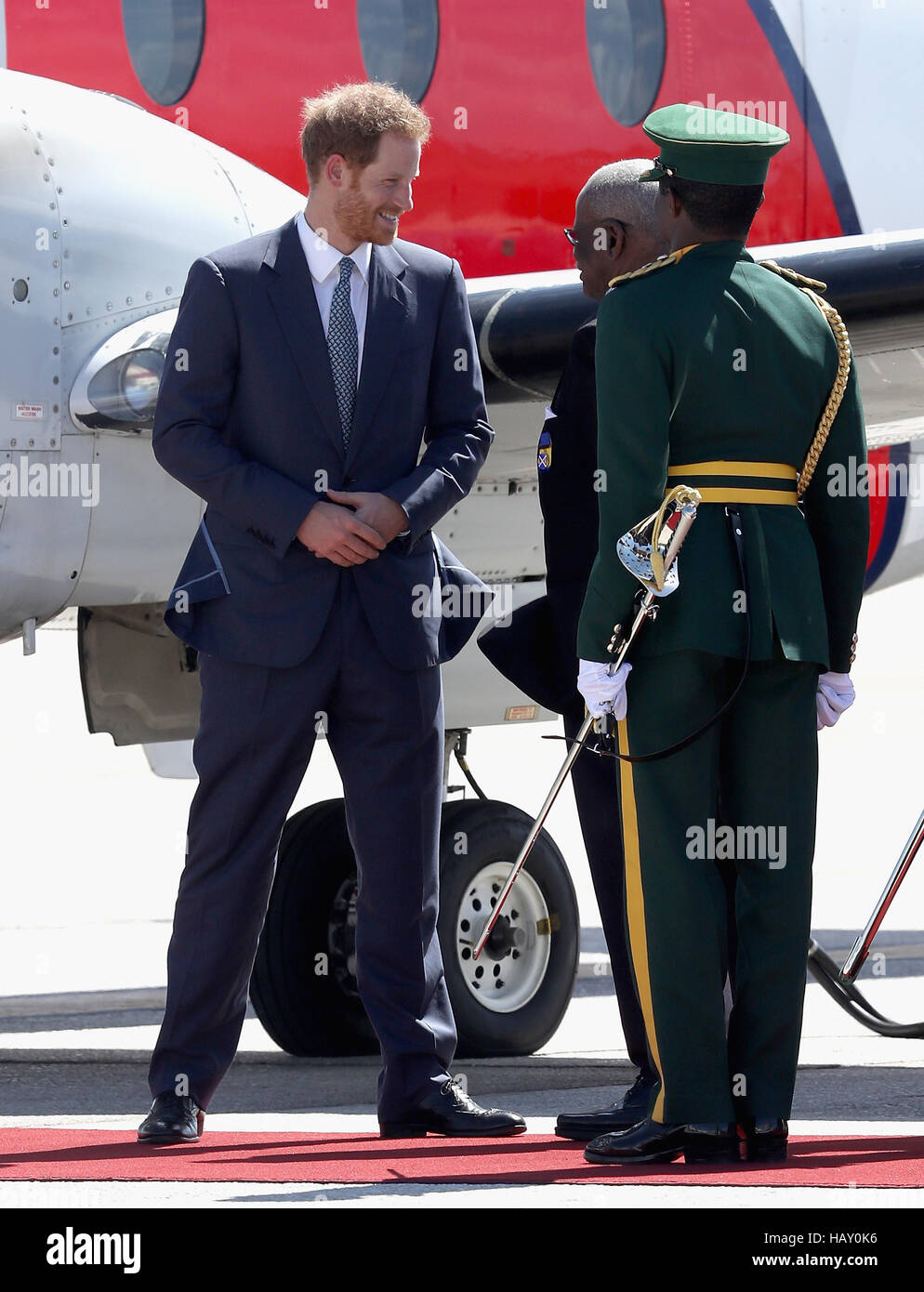 Il principe Harry parla con il Governatore Generale Elliott Belgrave (centro) come egli si prepara a lasciare l'Aeroporto Internazionale Grantley Adams in Barbados come egli capi di Guyana, come parte del suo tour dei Caraibi. Foto Stock