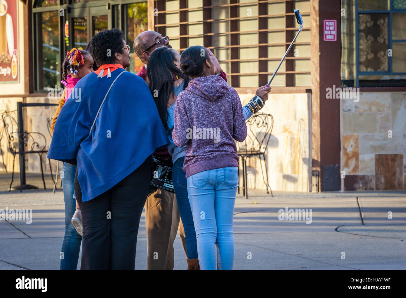 La famiglia in posa per una foto con un bastone selfie nella parte anteriore del Mondo di Coca Cola in downtown Atlanta, la Georgia a Pemberton posto. Foto Stock