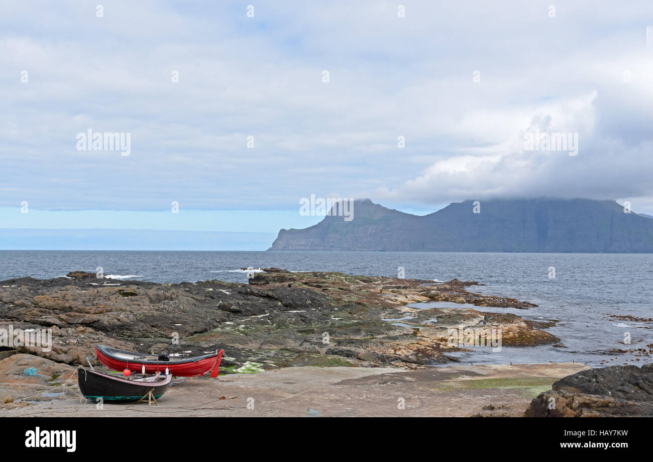 Due piccole barche di pescatori sulle sponde rocciose di Gjogv, Isole Faerøer, Danimarca Foto Stock