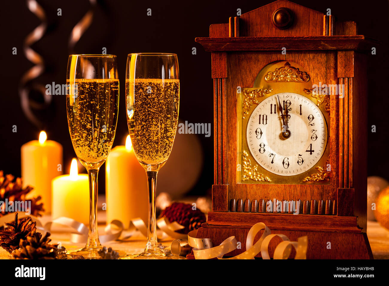 Due bicchieri di champagne e un orologio vintage a un cenone di capodanno con ballo. Foto Stock