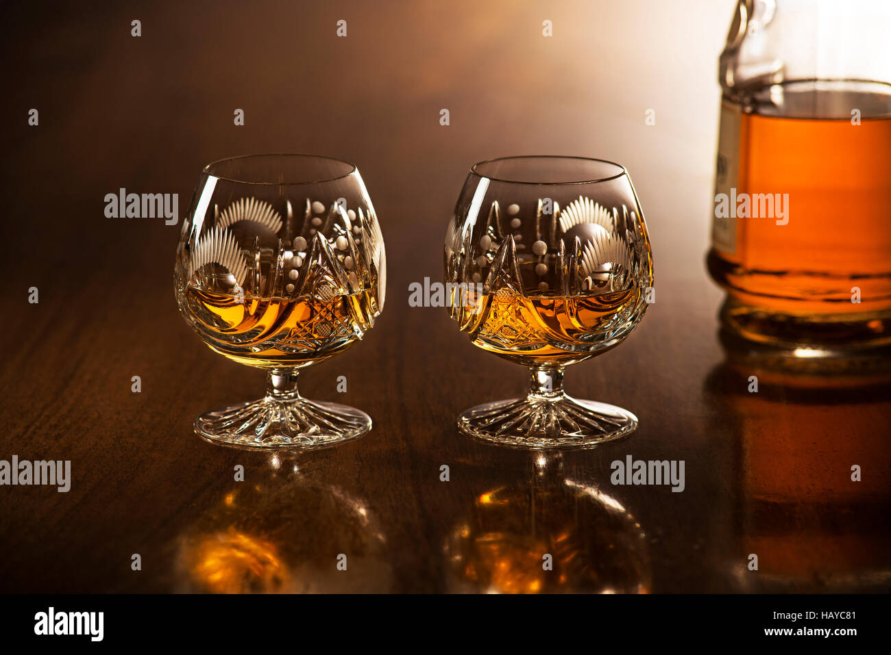Cognac in vetro con bottiglia sul tavolo di legno Foto Stock