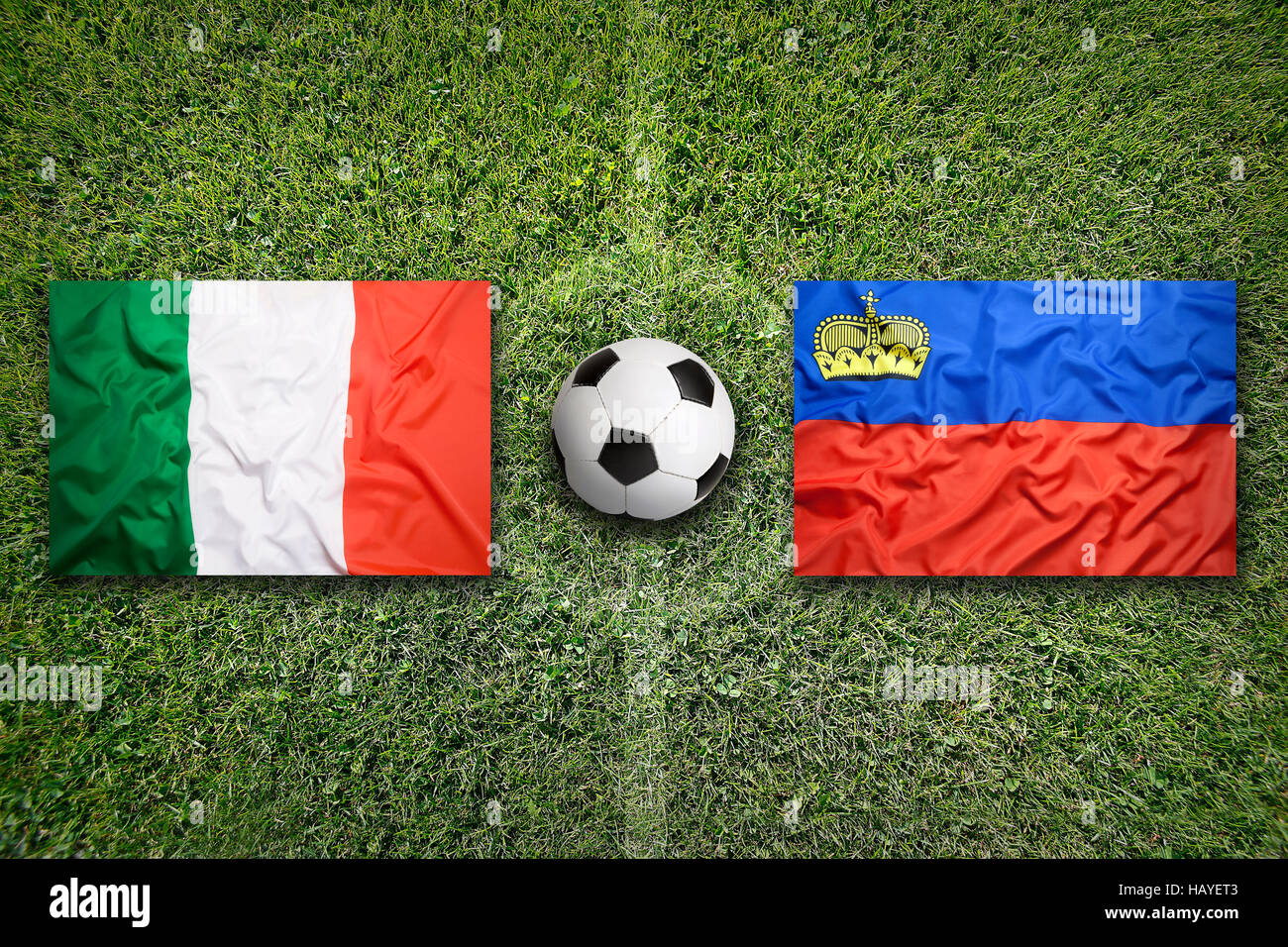 Italia vs. Liechtenstein bandiere su un verde campo di calcio Foto Stock