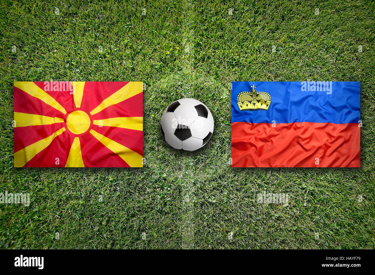 Il Liechtenstein vs. Macedonia bandiere su un verde campo di calcio Foto Stock