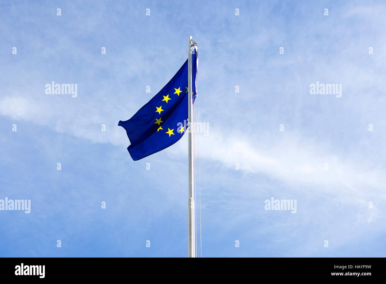 Bandiera dell'Unione europea su un pennone di fronte blu cielo Foto Stock