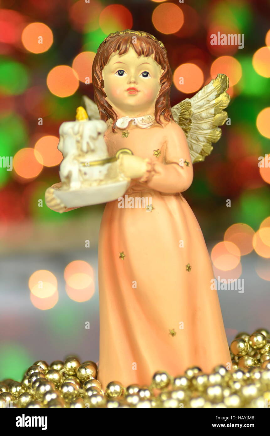 Decorazione di natale, la figura di little angel cantando canti natalizi contro sfondo bokeh di fondo Foto Stock