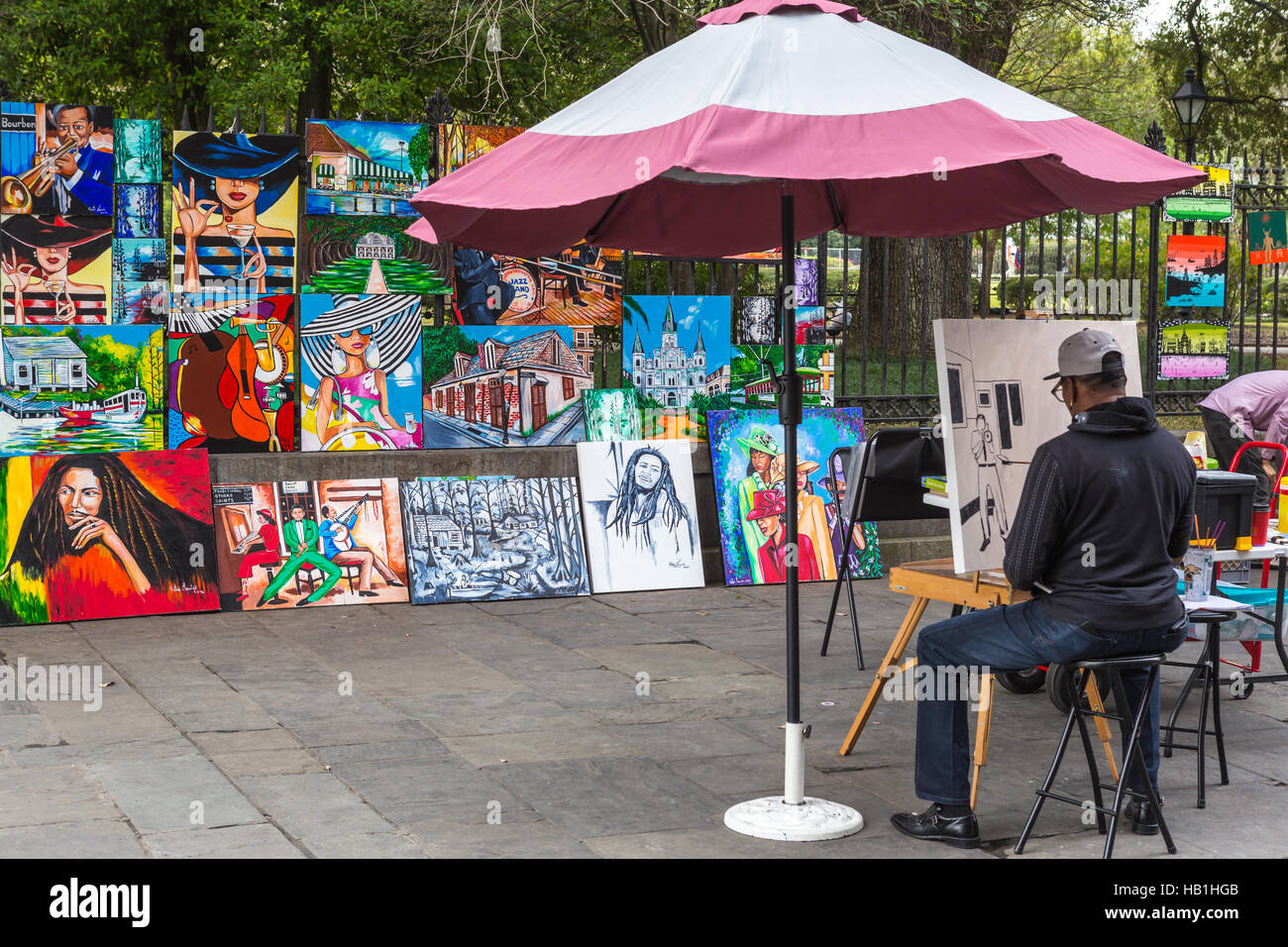Un pittore opere di fronte la sua opera per la vendita in Jackson Square a New Orleans, Louisiana. Foto Stock