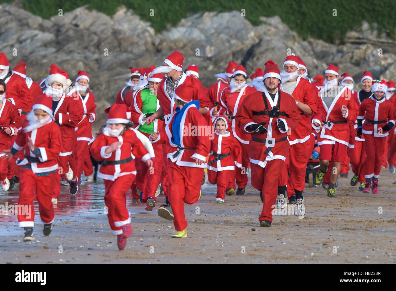 Newquay, Regno Unito. 04 Dic, 2016. Fistral Beach;, Newquay Cornwall. 4 dicembre, 2016. Centinaia di Babbo Natale girato fuori per una raccolta fondi della fun run attraverso una fredda Fistral Beach nell'annuale Santa esecuzione in Newquay, Cornwall. Fotografo Credito: Gordon Scammell/Alamy Live News Foto Stock