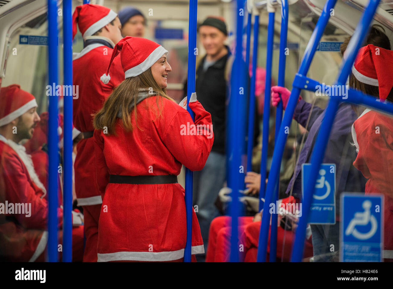 Londra, Regno Unito. 4° dic, 2016. I partecipanti arrivano da tubo - Thosuands dei corridori di tutte le età in santa tute e altri costumi di Natale runaround Clapham Common per Great Ormond Street Hospital e per il divertimento. Credito: Guy Bell/Alamy Live News Foto Stock