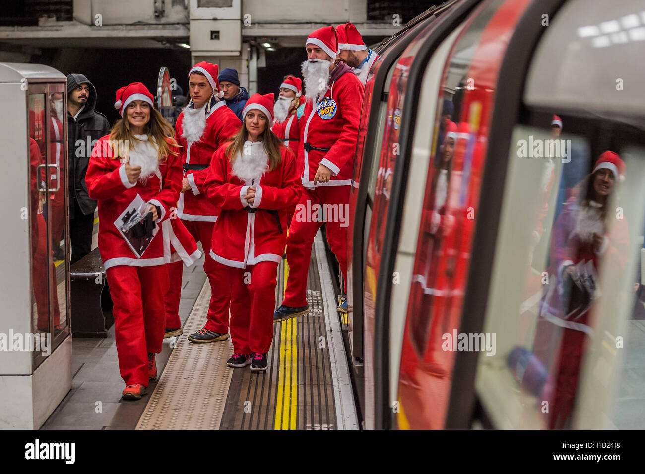 Londra, Regno Unito. 4° dic, 2016. I partecipanti arrivano da tubo - Thosuands dei corridori di tutte le età in santa tute e altri costumi di Natale runaround Clapham Common per Great Ormond Street Hospital e per il divertimento. Credito: Guy Bell/Alamy Live News Foto Stock