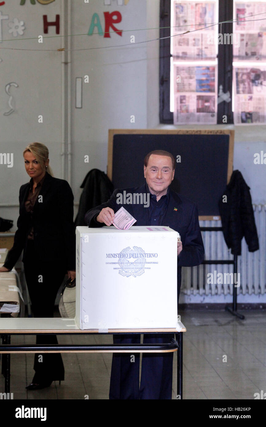 Silvio Berlusconi, con uno stand per sondaggi per segnare il suo voto al referendum sulla riforma costituzionale Foto Stock
