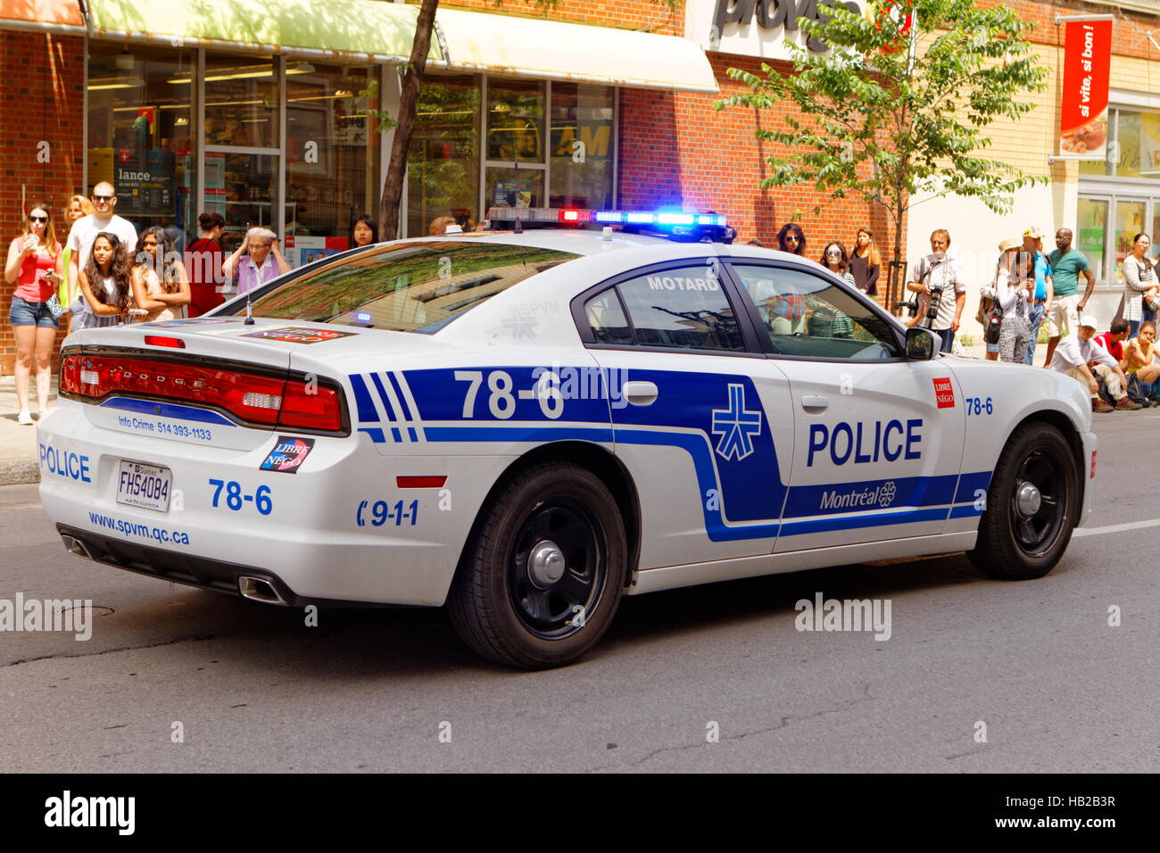 Una macchina della polizia voce giù Ste-Catherine street nel centro di Montreal Foto Stock
