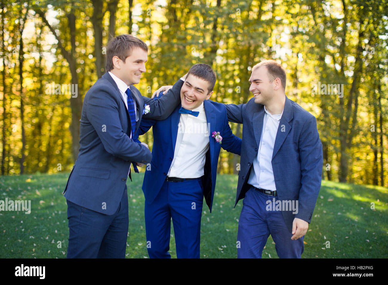 Gli amici di ridere al matrimonio di un amico Foto Stock