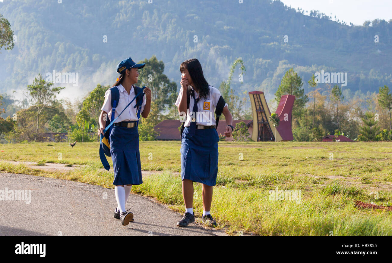 Due ragazze ridere sul modo per scuola di mattina Foto Stock