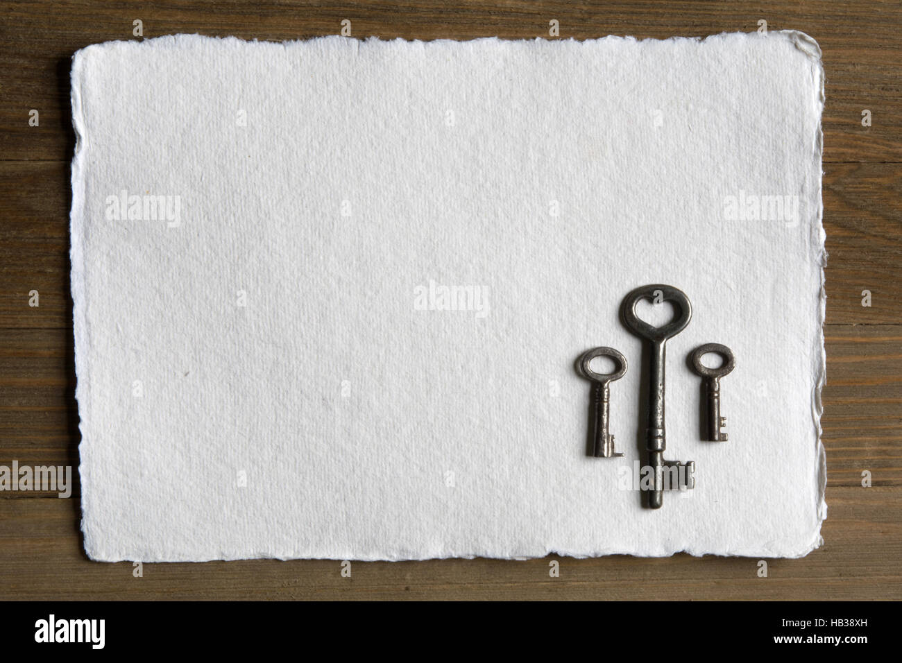 Scheletro di antiquariato con chiave a forma di cuore ad apertura contro carta bianca Foto Stock