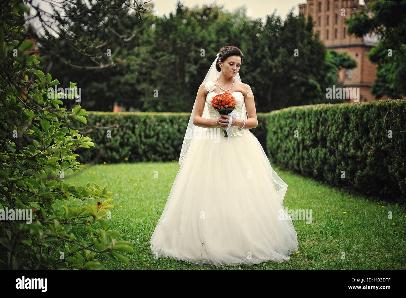 Bruna sposa con bouquet di nozze a portata di mano Foto Stock