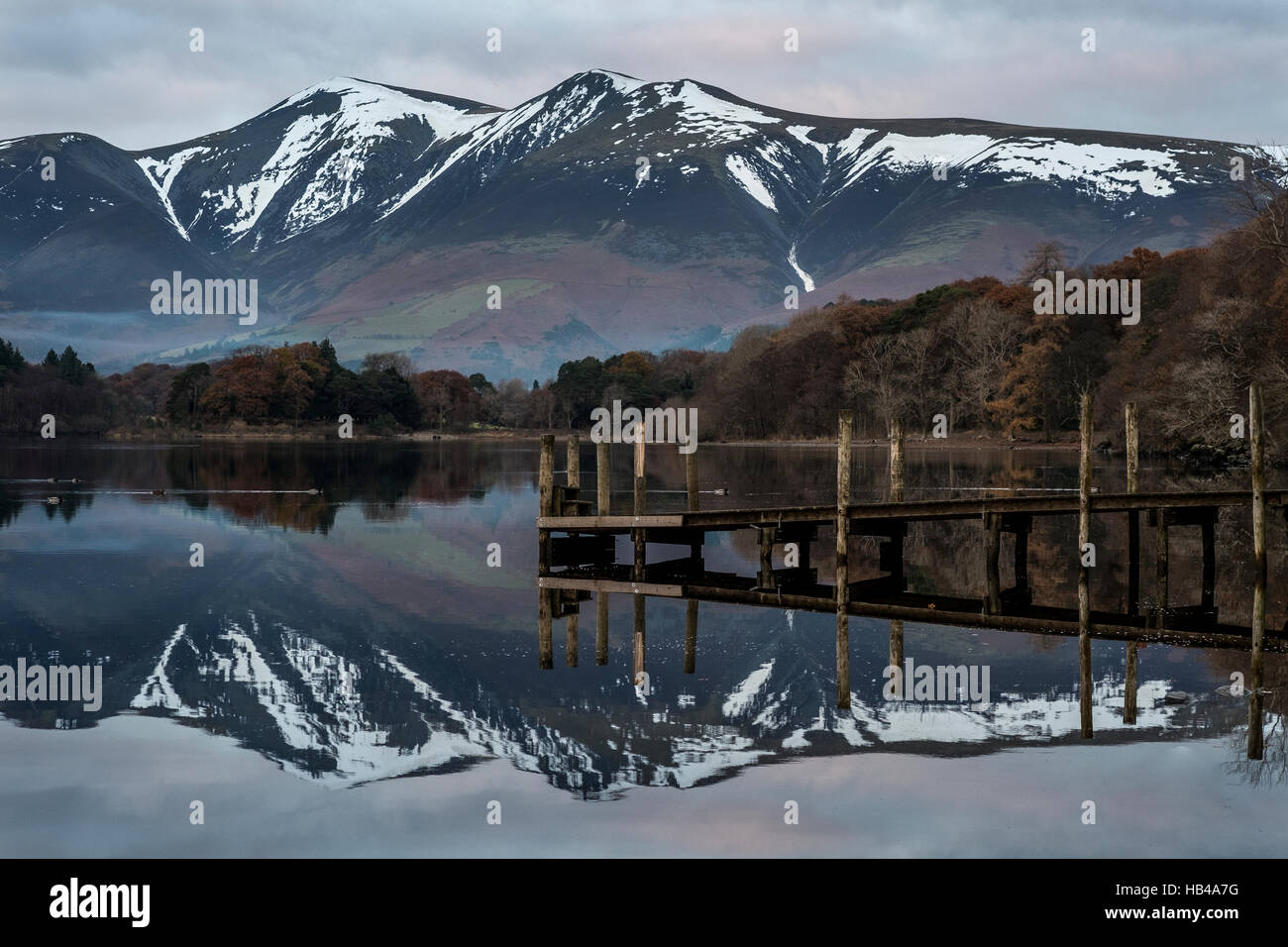 Tramonto su Derwent Water nel distretto del lago con Skiddaw torreggianti sopra alta. Foto Stock