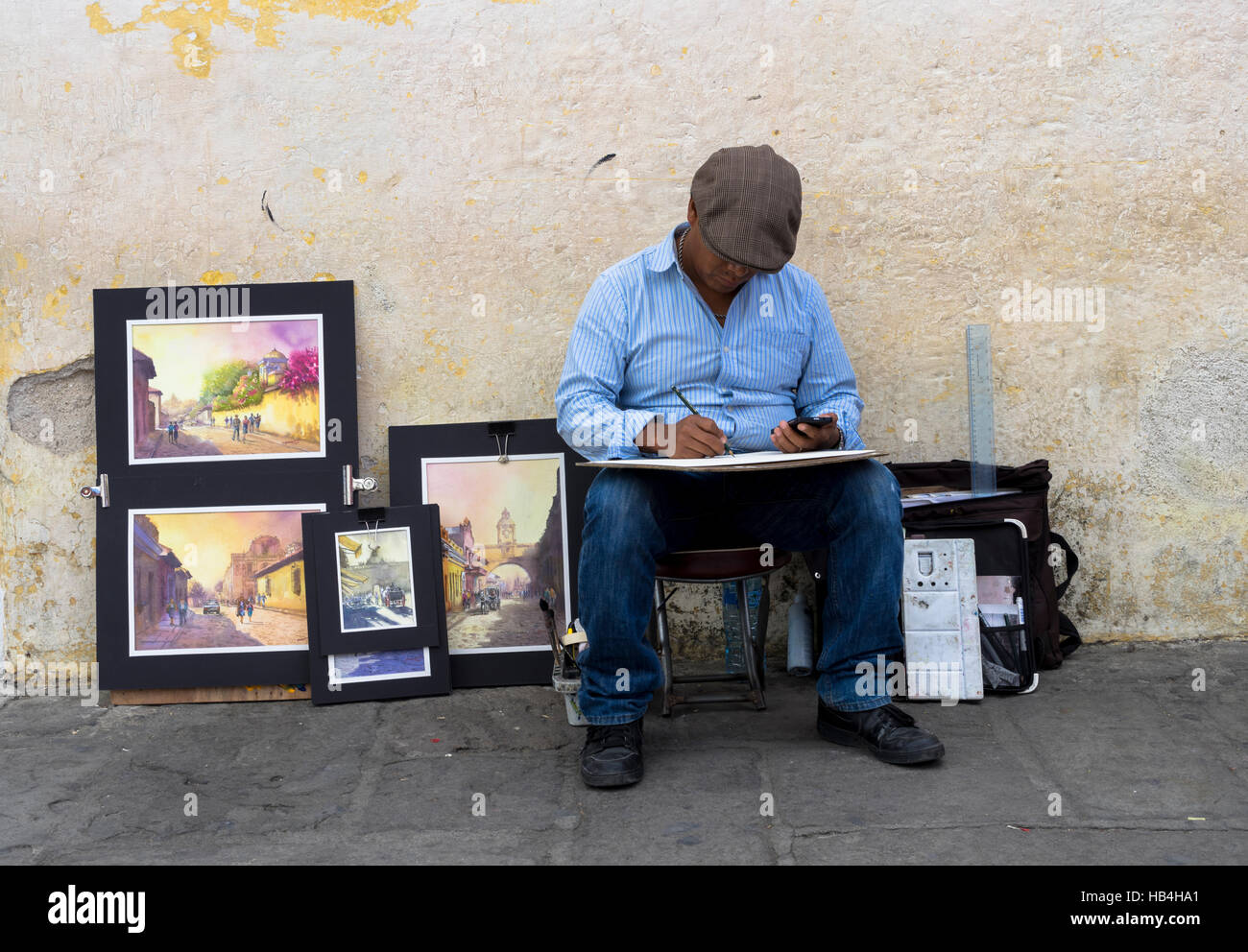 Artista pittura e vendere la sua arte da marciapiede, Antigua, Guatemala Foto Stock
