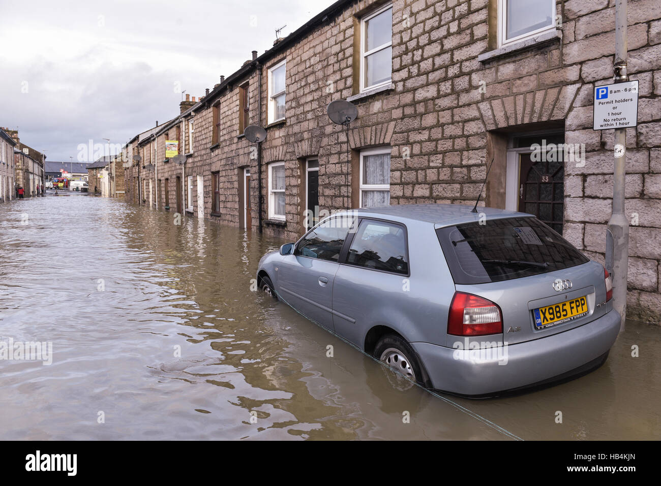 Un veicolo abbandonato in acqua di inondazione in una strada a Kendal Cumbria, il 6 dicembre 2015. Foto Stock