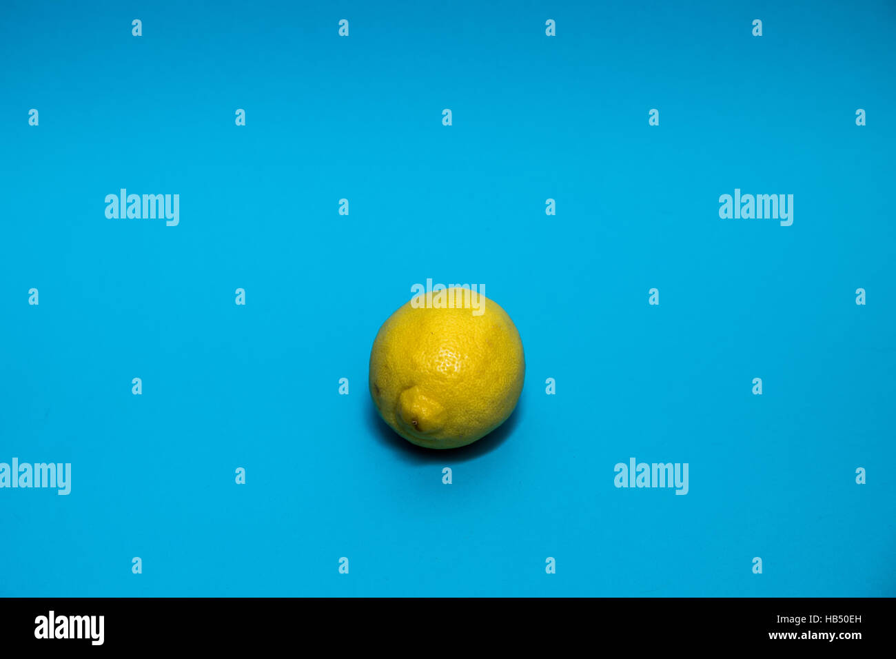 Limone giallo contro uno sfondo blu Foto Stock