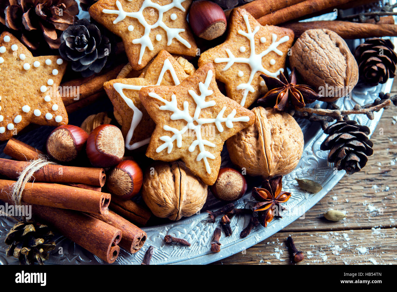 Decorazioni di Natale con fatti in casa gingerbread cookies stelle, coni, i dadi e le spezie di Natale su legno rustico sfondo con spazio di copia Foto Stock