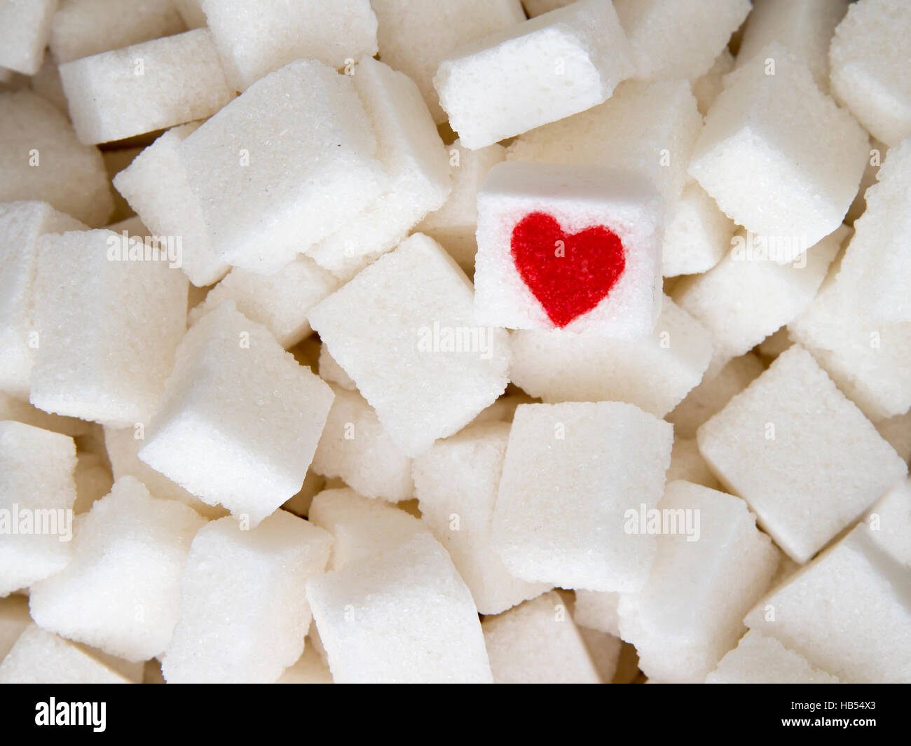 Zollette di zucchero con un cuore rosso su uno di essi. Vista dall'alto.  Dieta dolce unhealty concetto di dipendenza Foto stock - Alamy