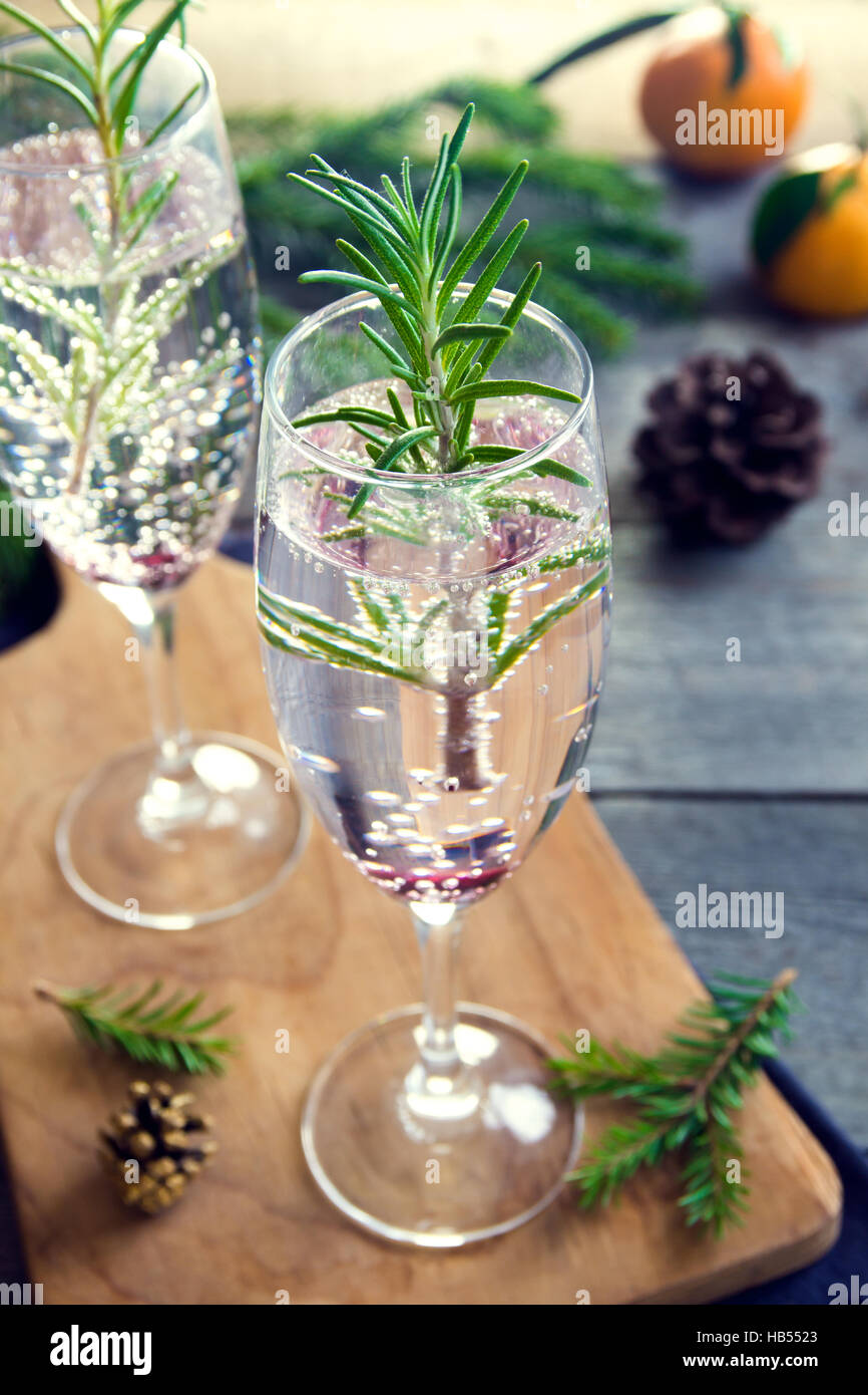 Mimosa drink di festa per il Natale - champagne cocktail con rosmarino per la festa di Natale Foto Stock