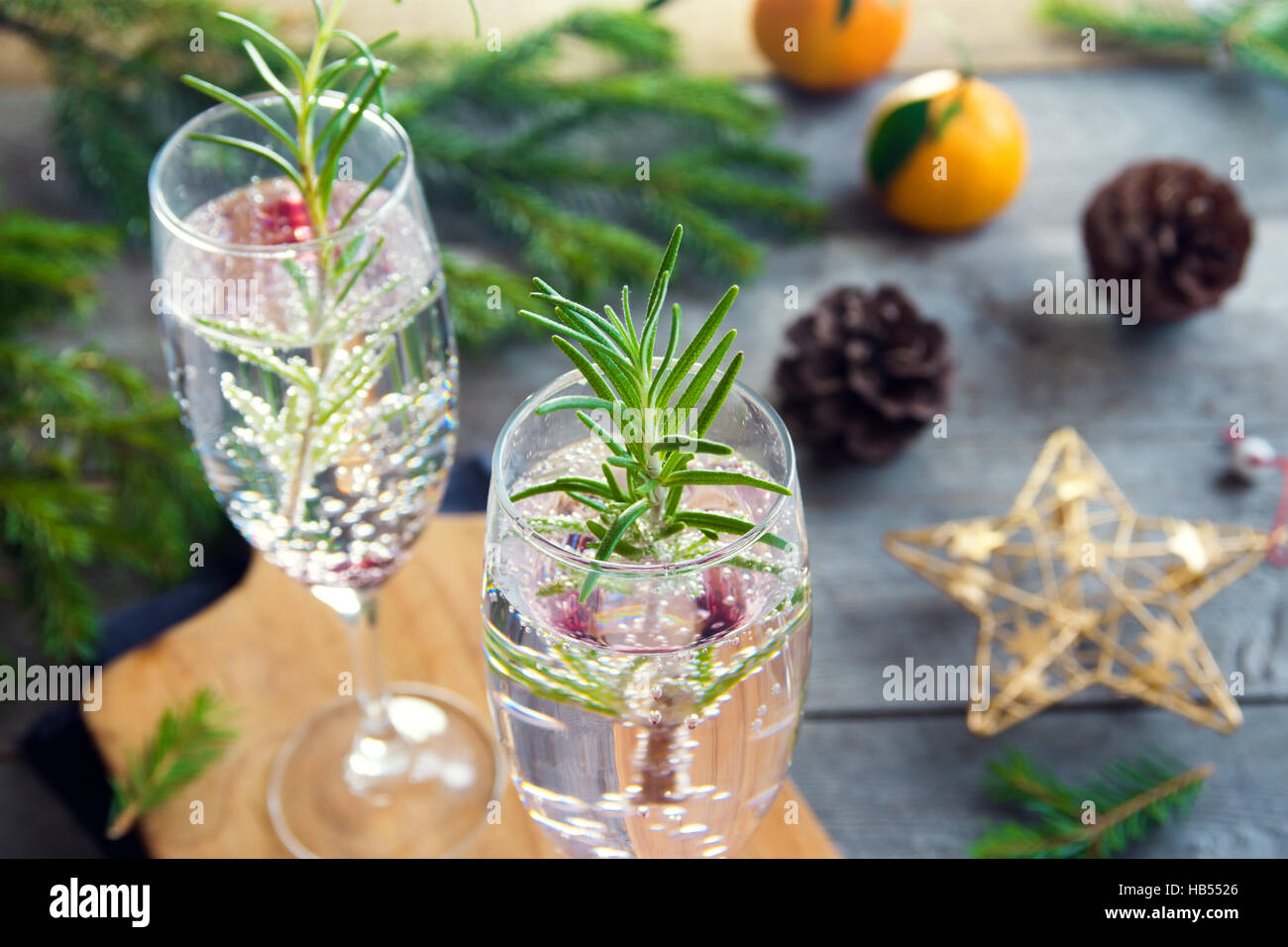 Mimosa drink di festa per il Natale - champagne cocktail con rosmarino per la festa di Natale Foto Stock