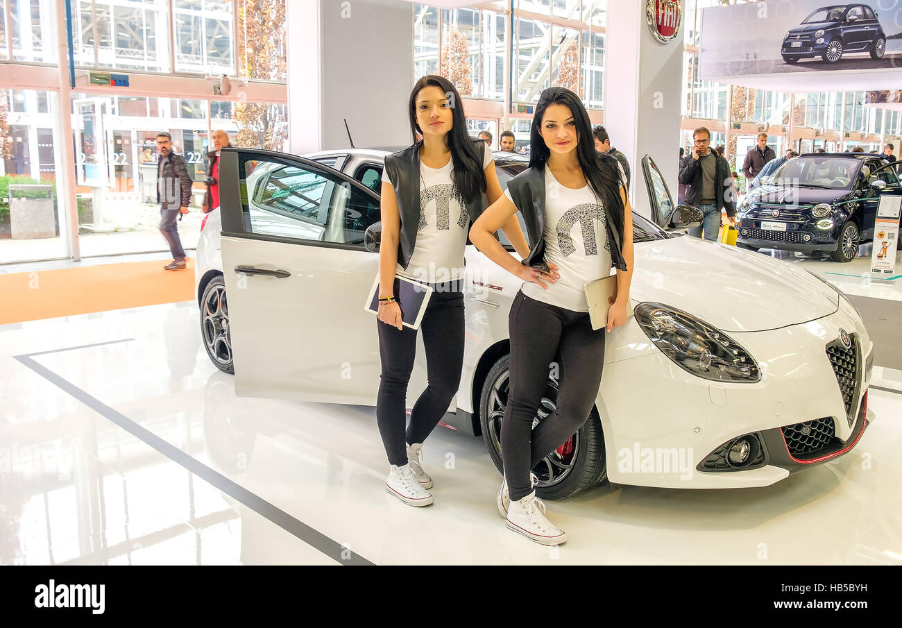 Bologna, Italia, 03 dic. 2016 - Due modelli di Bruna in posa appoggiata ad un bianco Alfa Romeo Giulietta auto in stand Fiat del Motorshow 2016 in Bolog Foto Stock