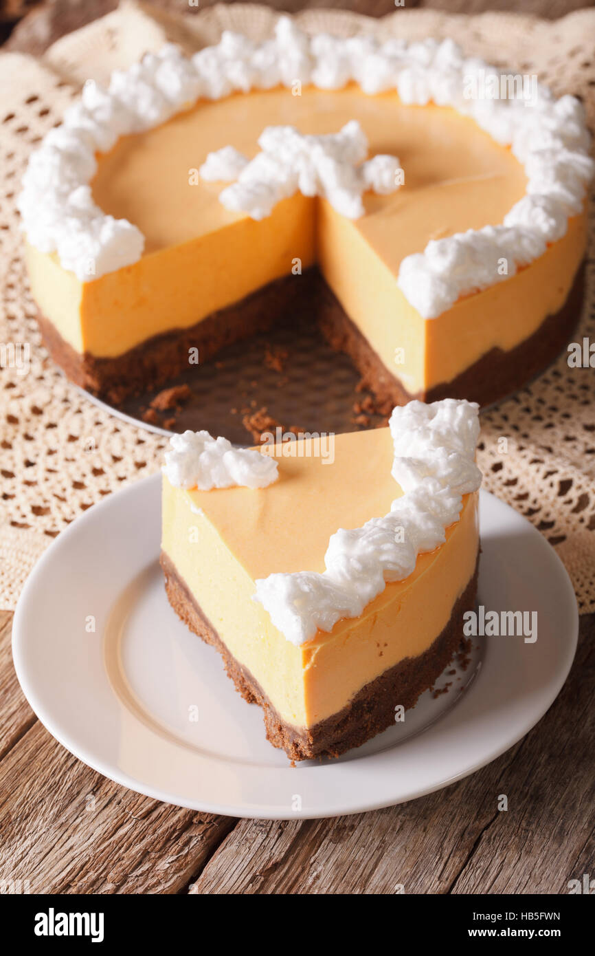 Tagliate il formaggio di zucca torta decorata con panna montata su una piastra sul piano verticale. Foto Stock