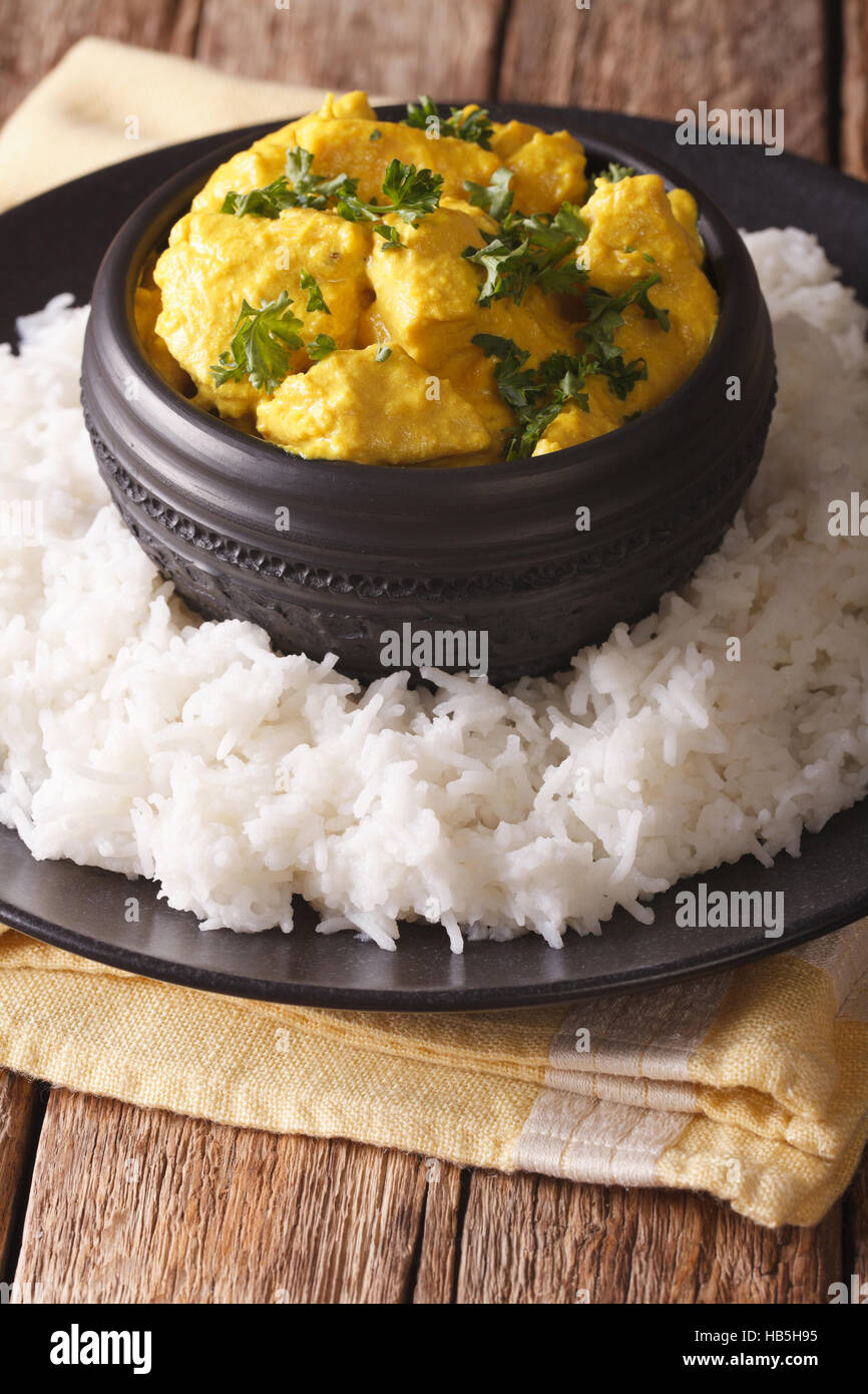 Indiano Korma di pollo con riso basmati vicino sul tavolo. In verticale Foto Stock