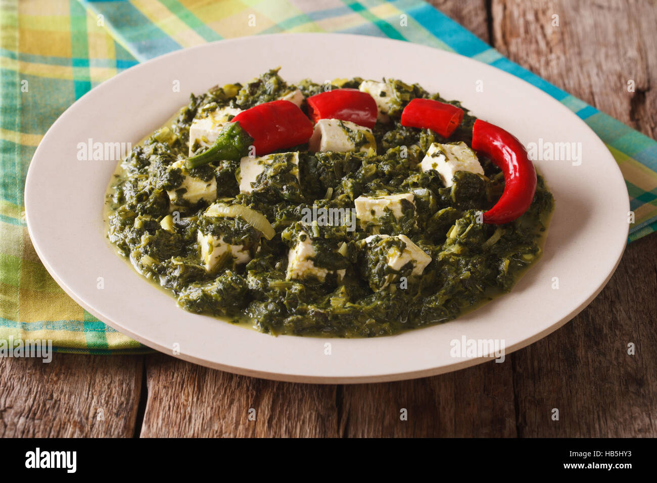 Palak paneer con spinaci, formaggio e peperoncino un close-up su una piastra orizzontale. Foto Stock