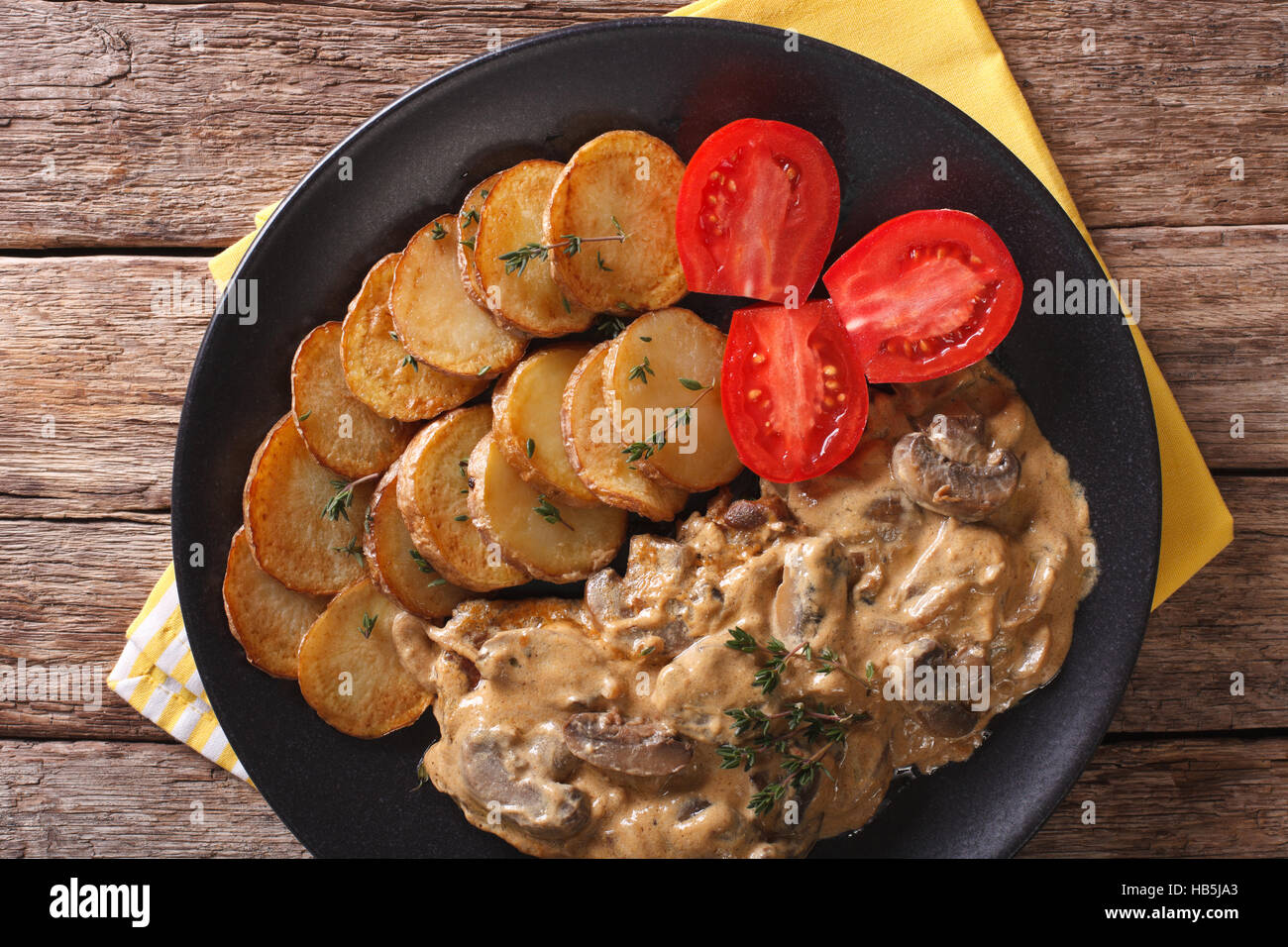 Diana bistecca con funghi porcini e patate arrosto close-up su una piastra orizzontale di vista da sopra Foto Stock