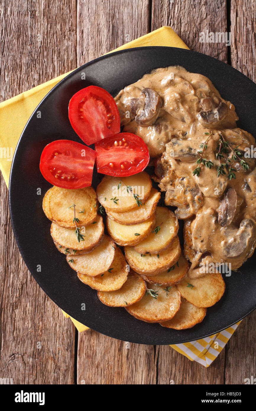 Diana bistecca con funghi e salsa alla panna close-up su una piastra. Vista verticale da sopra Foto Stock