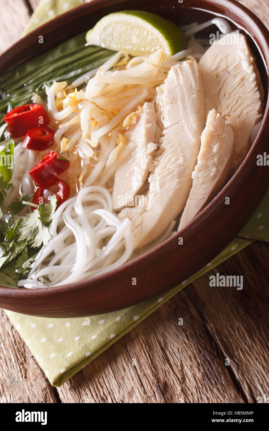 Zuppa vietnamita pho ga con pollo e riso tagliatelle in una ciotola di close-up verticale. Foto Stock