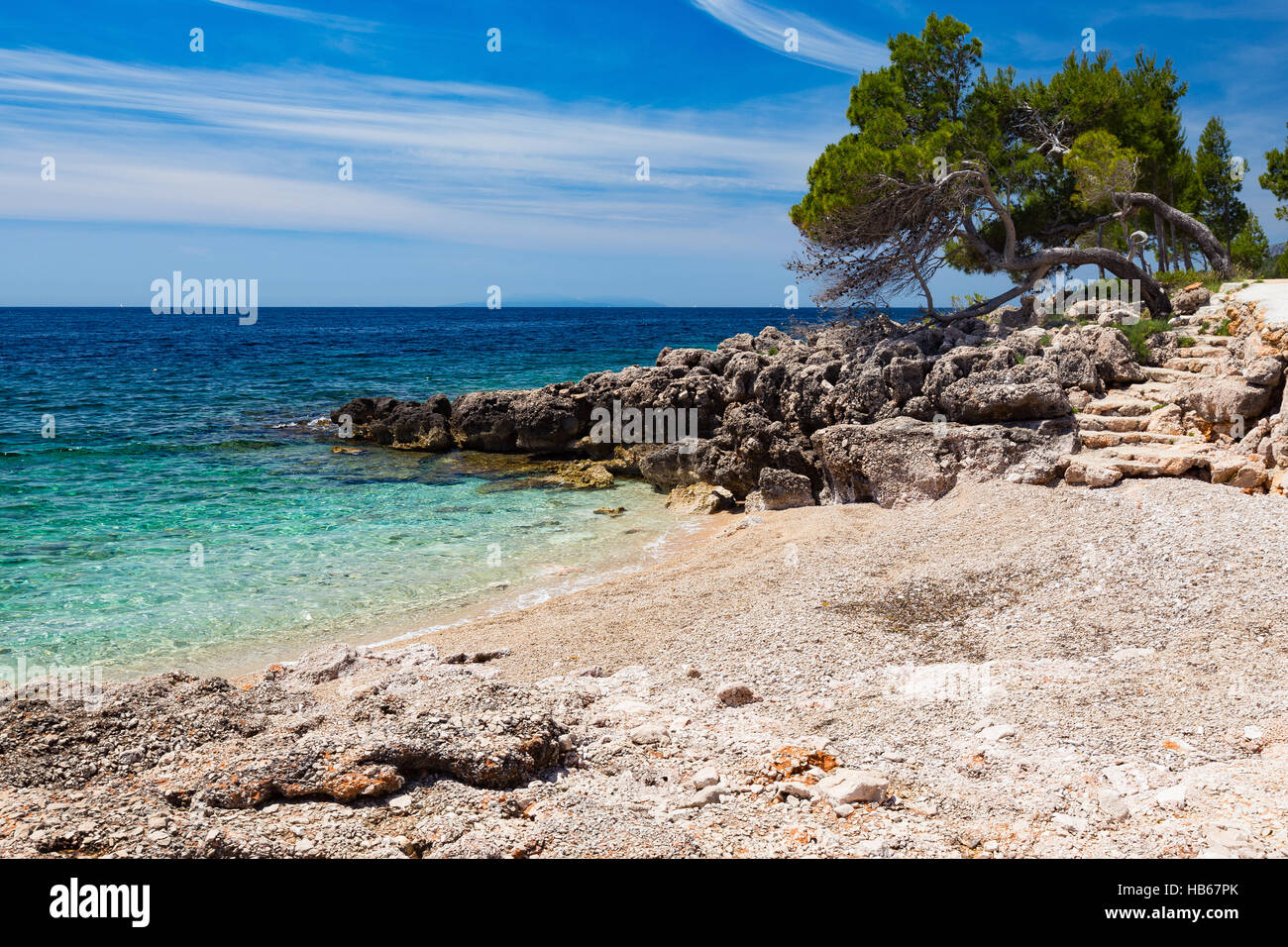 Spiaggia rocciosa e alberi. Mare Adriatico. Isand Hvar, Croazia. Europa. Foto Stock