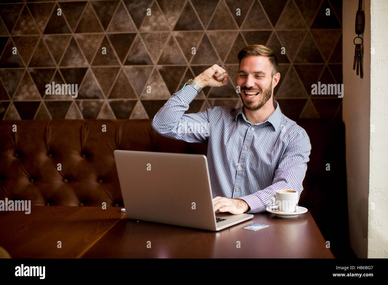 Giovane uomo utilizza un laptop e guardare avanti a qualcosa di Foto Stock