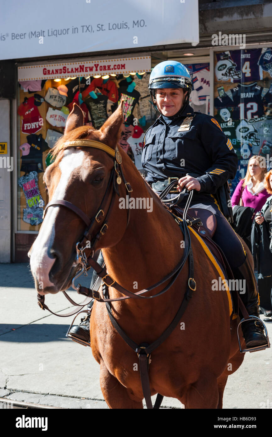 Una femmina di New York funzionario di polizia a cavallo guarda i turisti a Times Square Manhattan Foto Stock