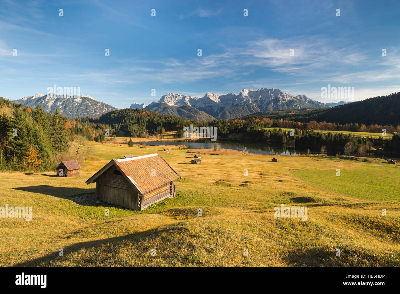 Pagliaio sopra il lago di Gerold e sulle montagne del Karwendel Circondato da colorati humpy prati e bosco in autunno nel pomeriggio la luce solare, Baviera, Germania Foto Stock