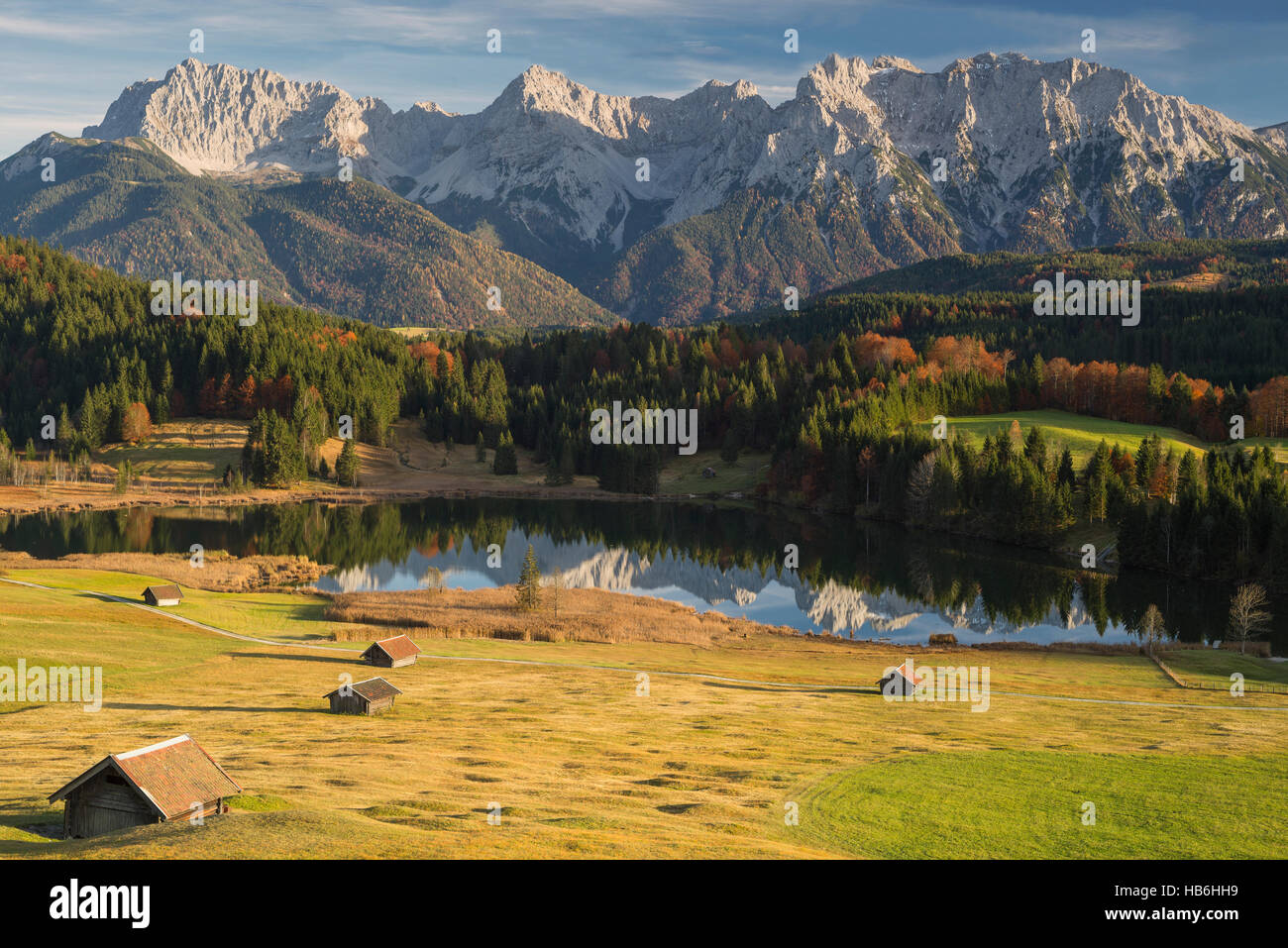 Scogliere e rocce della montagna Karwendel dietro il Lago Geroldsee e foreste autunnali nel sole del pomeriggio, Alta Baviera, Germania Foto Stock