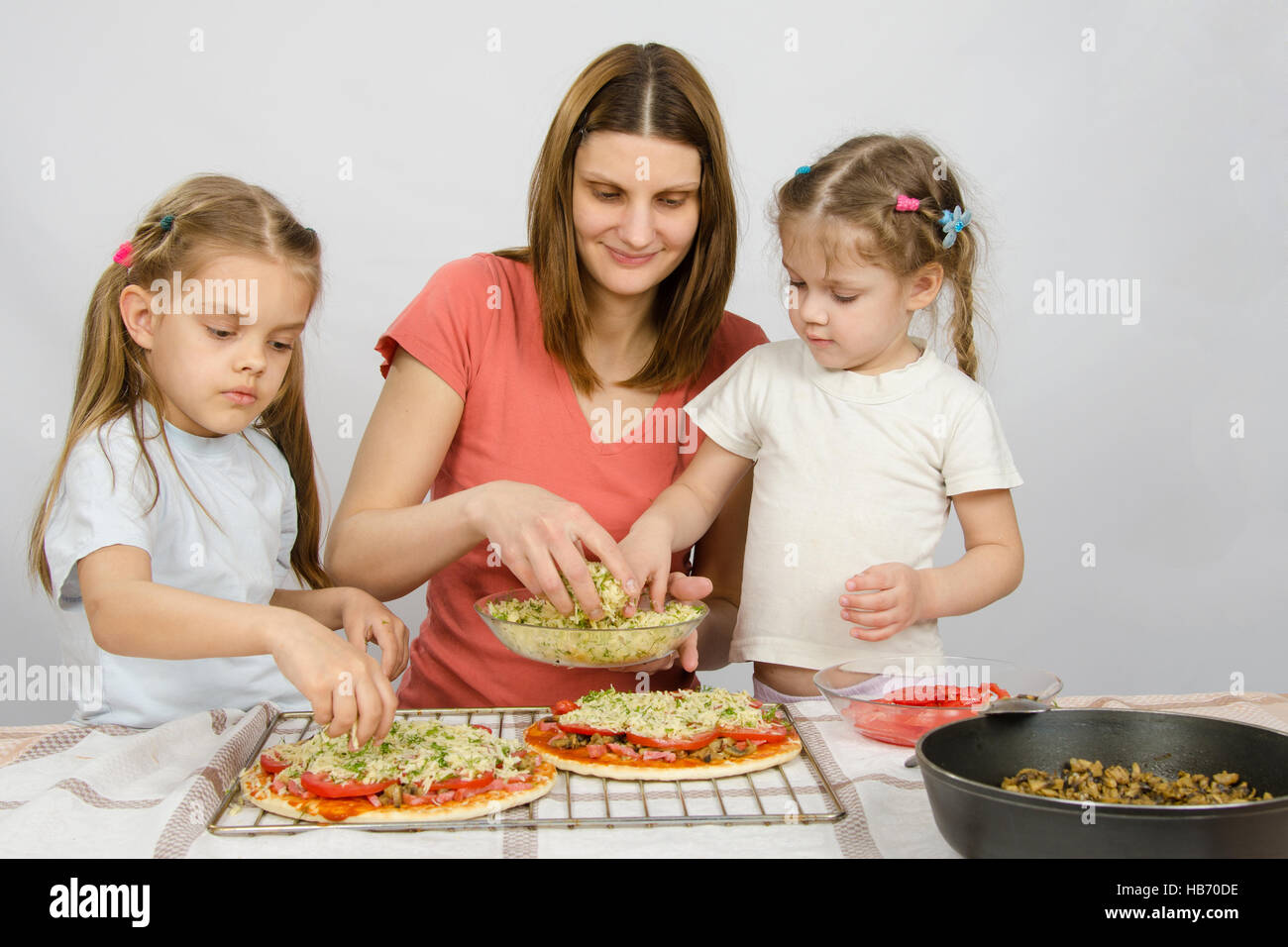 Mom con due giovani assistenti fare la pizza Foto Stock