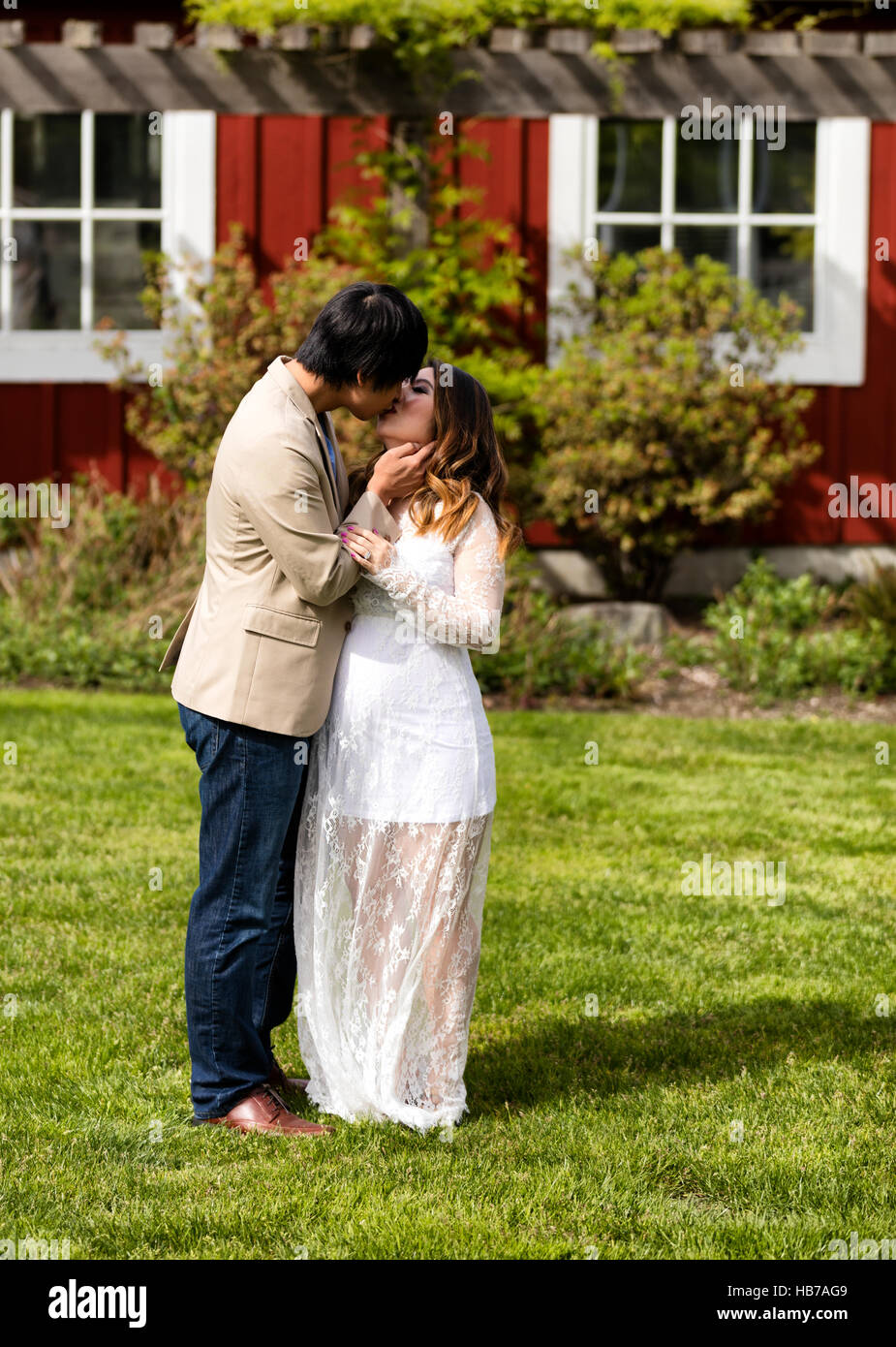 Aspettano di mamma e papà kissing al di fuori Foto Stock