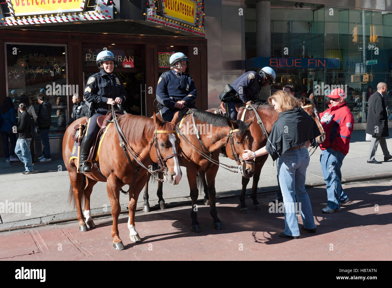 Polizia, tre agenti di polizia della polizia di New York a cavallo interagiscono con i turisti a Times Square, Manhattan, New York City Foto Stock