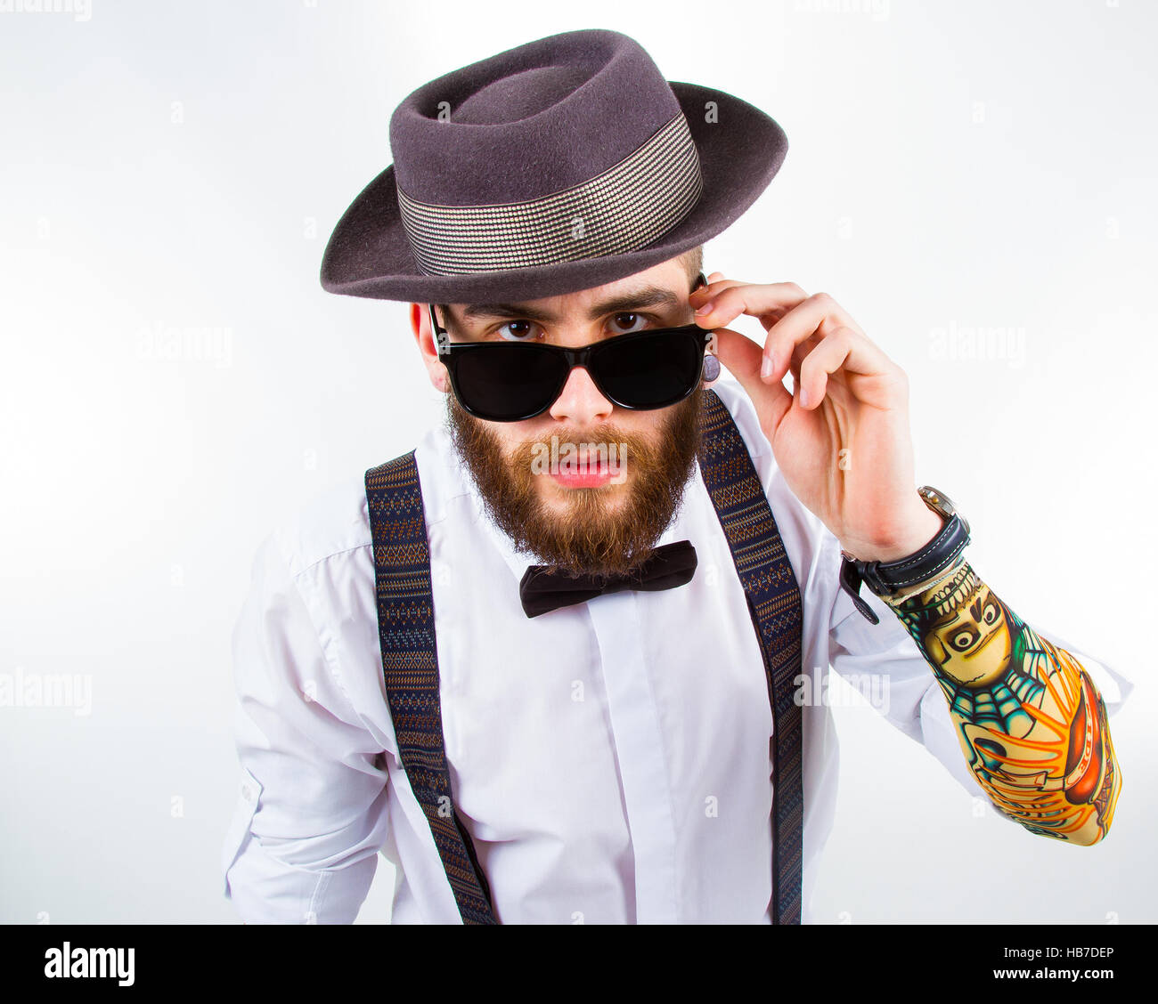 Tanga giovane uomo che indossa hat , autoreggenti , un bow tie-in e una  divertente tattoo e manicotto Foto stock - Alamy
