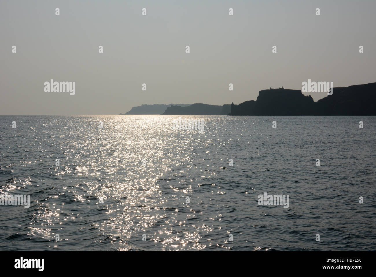 Tre promontori nella nebbia con la riflessione in un mare calmo Foto Stock