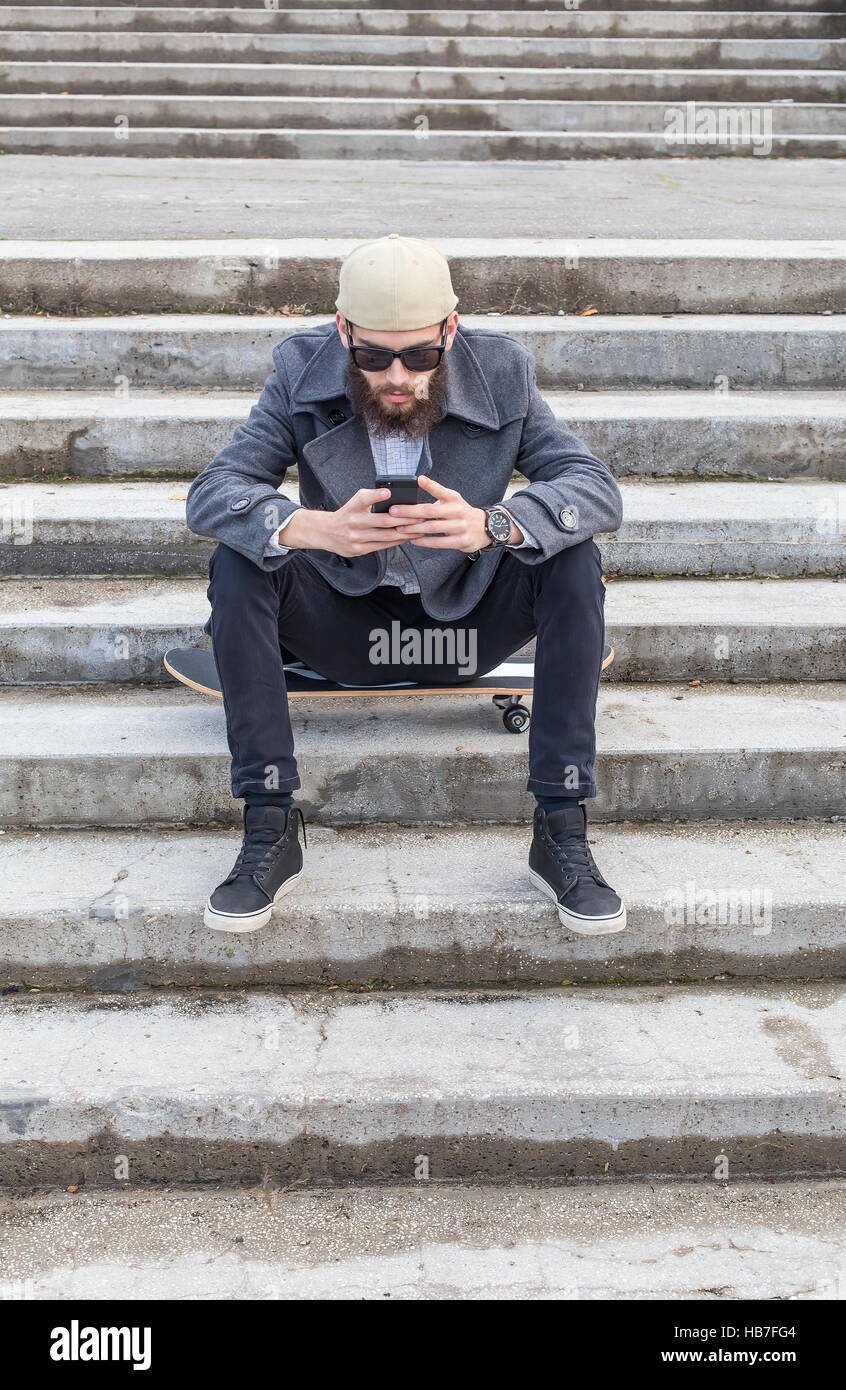 Guy utilizzando wireless fidelity in città. Foto Stock